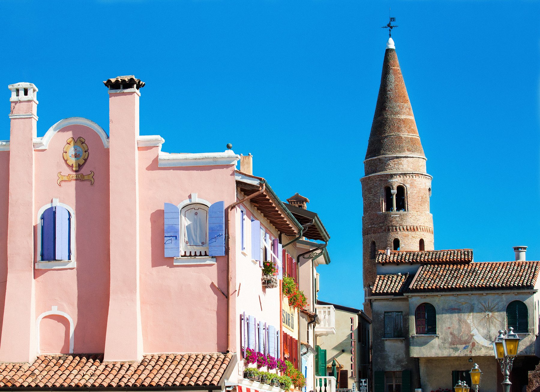Campanile cilindrico di Caorle con le case rosa del borgo