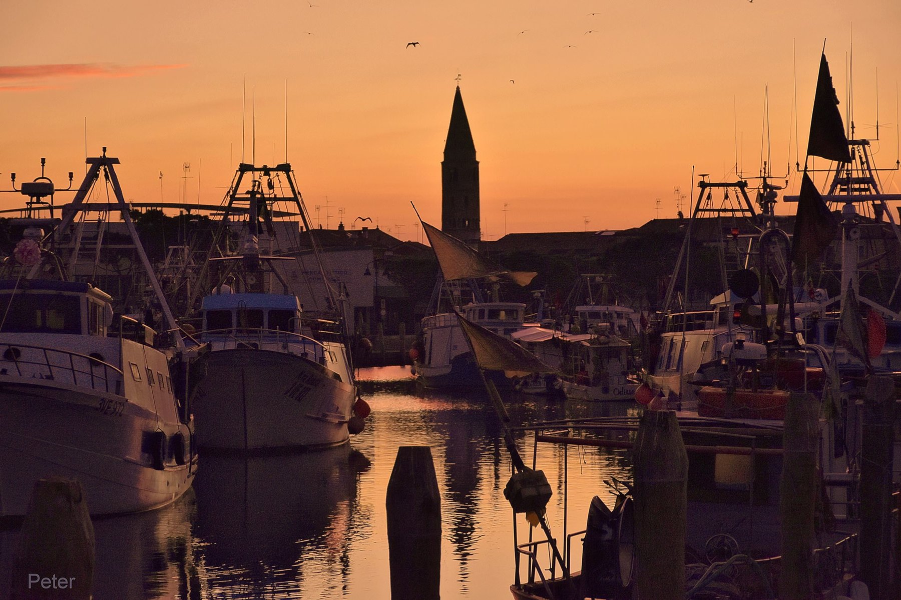 Porto peschereccio di Caorle al tramonto con il campanile